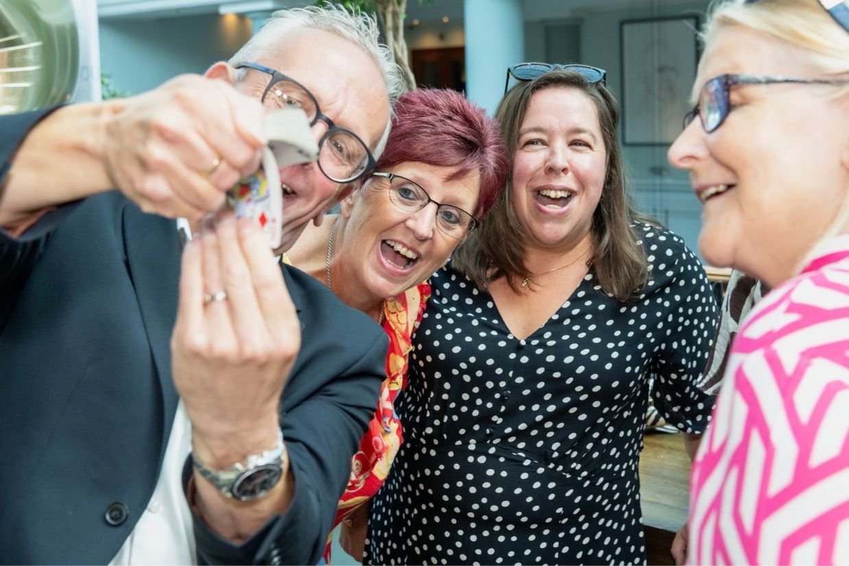 Guests laughing at a corporate magician's close-up magic
